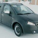 En liten svart bil kör på snö. (AI text)