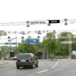 En bil körer nedför en gata med trafikljus. (AI text)
