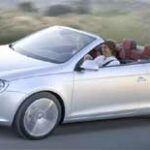 En Volkswagen Cabriolet kör nedför en väg. (AI text)