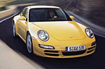 En gul Porsche 911 GTS kör nerför en väg. (AI text)