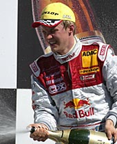 en raceförare firar efter att ha vunnit Audi A3-mästerskapet (AI text)