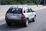 En silversvart SUV kör nedför en motorväg. (AI text)