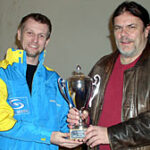 En man och en kvinna håller upp pokalen. (AI text)