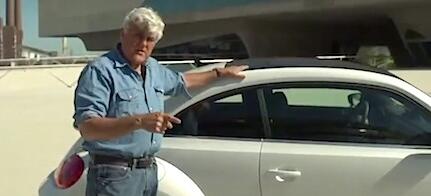 En man står bredvid en Volkswagen Käfer. (AI text)