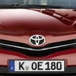 En röd Toyota Avanza parkerad på en gata. (AI text)