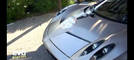 En silverfärgad sportbil parkerad i en uppfart. (AI text)