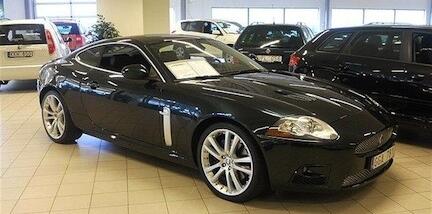En svart Jaguar XK kupé i en showrum (AI text)