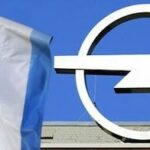 GM-logga och flagga framför ett byggnad (AI text)