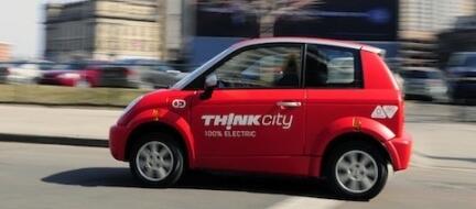 En röd bil kör nerför en stadsgata. (AI text)