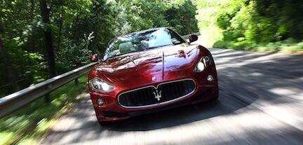 En Maserati Granturismo kör nedför en landsväg. (AI text)