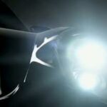 En svart sportbil med tändningsljus på. (AI text)