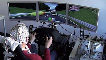 En man kör en bil i en simulator. (AI text)