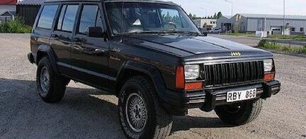 En svart Jeep parkerad på grusade parkeringsplatsen. (AI text)