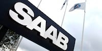 Saab-logotypen framför ett byggnad. (AI text)