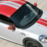 En Mini Cooper S parkerad på en gata. (AI text)