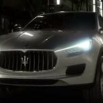 En Maserati SUV kör nedför gatan på natten. (AI text)