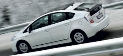 En vit Toyota Prius kör nerför en snöig väg. (AI text)
