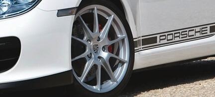 En vit Porsche 911 GTS parkerad på en grusväg. (AI text)