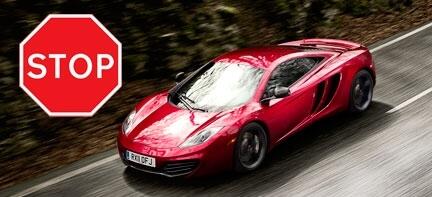 En röd sportbil kör nerför en väg med ett hastighetsbegränsningsmärke. (AI text)