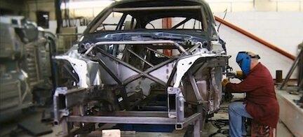 En man arbetar med en bil i en garage. (AI text)