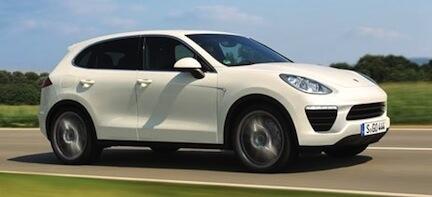 En vit Porsche Cayenne kör nerför en landsväg. (AI text)