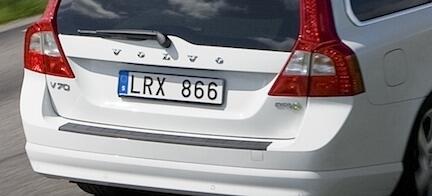 En vit Volvo V40 kör nedför en väg. (AI text)