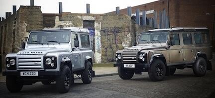 Två Land Rover Defender parkerade framför ett byggnad. (AI text)