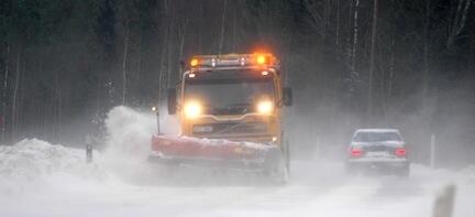 En snöröjare kör nedför en snöig väg. (AI text)