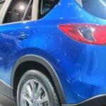 En blå Mazda CX-5 SUV utställd på bilmässan. (AI text)
