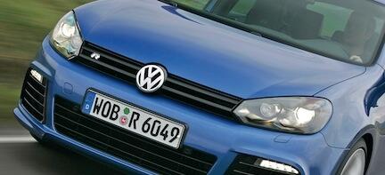 En blå Volkswagen Golf R GTI kör nerför en landsväg. (AI text)