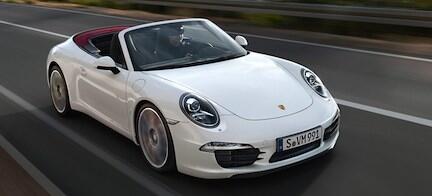 En vit Porsche 911 TT kör längs en väg. (AI text)