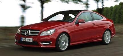 En Mercedes C-klass coupé kör på en väg. (AI text)