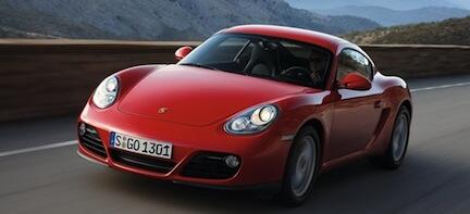 En röd Porsche Cayman kör nerför en bergsväg. (AI text)