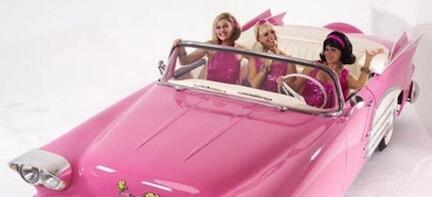En rosa cabriolet med två tjejer ombord. (AI text)