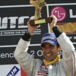 En racerförare håller upp sin pokal efter att ha vunnit Formel 1-världsmästerskapet. (AI text)