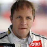 en racer i ett vitt racingdräkt (AI text)