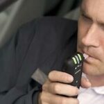 En man använder sin mobiltelefon i sin bil. (AI text)
