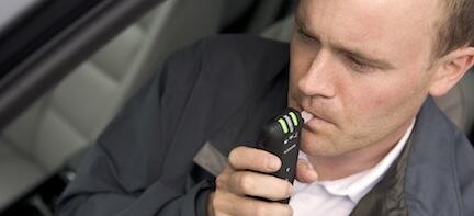 En man använder sin mobiltelefon i sin bil. (AI text)