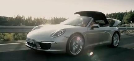 En silverfärgad Porsche 911 Targa TT kör på en väg. (AI text)