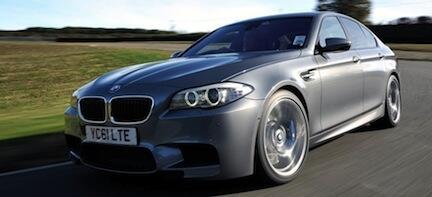 En BMW M5 kör på en väg. (AI text)