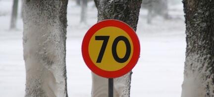 En skylt med nummer 70 på den snöiga ytan. (AI text)