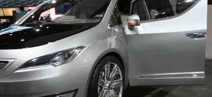 En silverfärgad bil med öpprat däck på en bilsalong. (AI text)