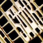 En guldbil med en grille och ett märkeslogo. (AI text)