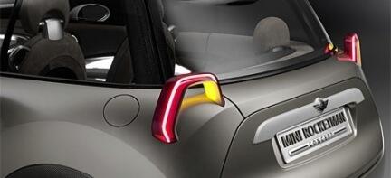 En Mini Cooper med en röd blinkers på bakluckan. (AI text)