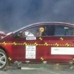 En bil får hjälp att rulla fram mot en mur. (AI text)