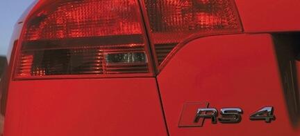 En röd bil med RS4-märket på bakrespoet. (AI text)