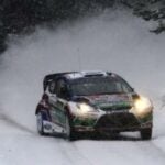 en rallybil körande längs en snöig väg (AI text)