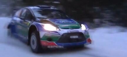 En Ford Fiesta rallybil kör genom snön. (AI text)