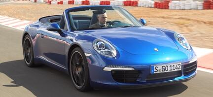 En blå Porsche 911 Targa S kör på en racerbana. (AI text)