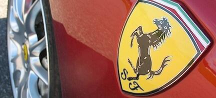 En Ferrari-sportsbil med ett emblema på huven. (AI text)